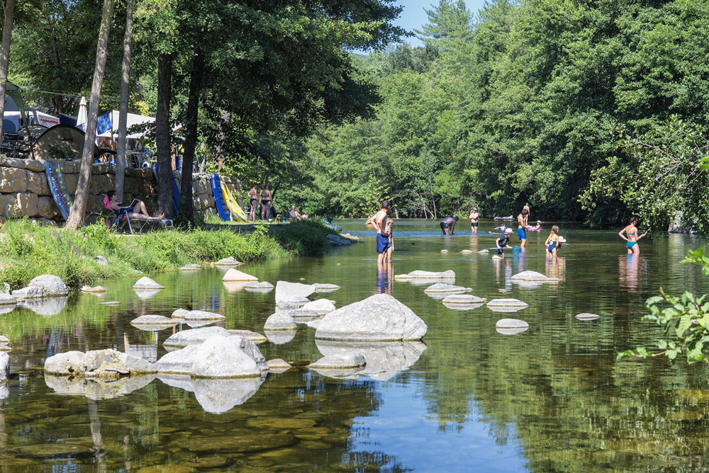 Camping dans les Cévennes en bord de rivière avec vacanciers qui se baignent